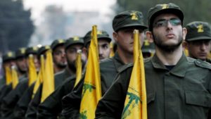 Combatientes de Hezbolá sostienen banderas del partido durante un desfile en un suburbio del sur de Beirut, Líbano (AP / Hussein Malla / Archivo)