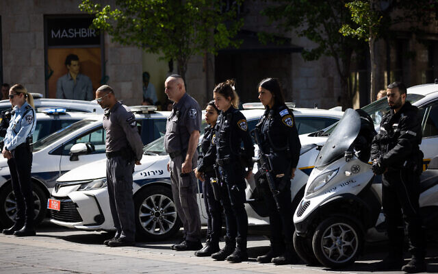 Los oficiales de policia se quedan quietos en Jerusalen mientras suena una sirena de dos minutos en todo Israel para conmemorar el Dia del Recuerdo del Holocausto el 18 de abril de 2023 (Yonatan Sindel/Flash90)